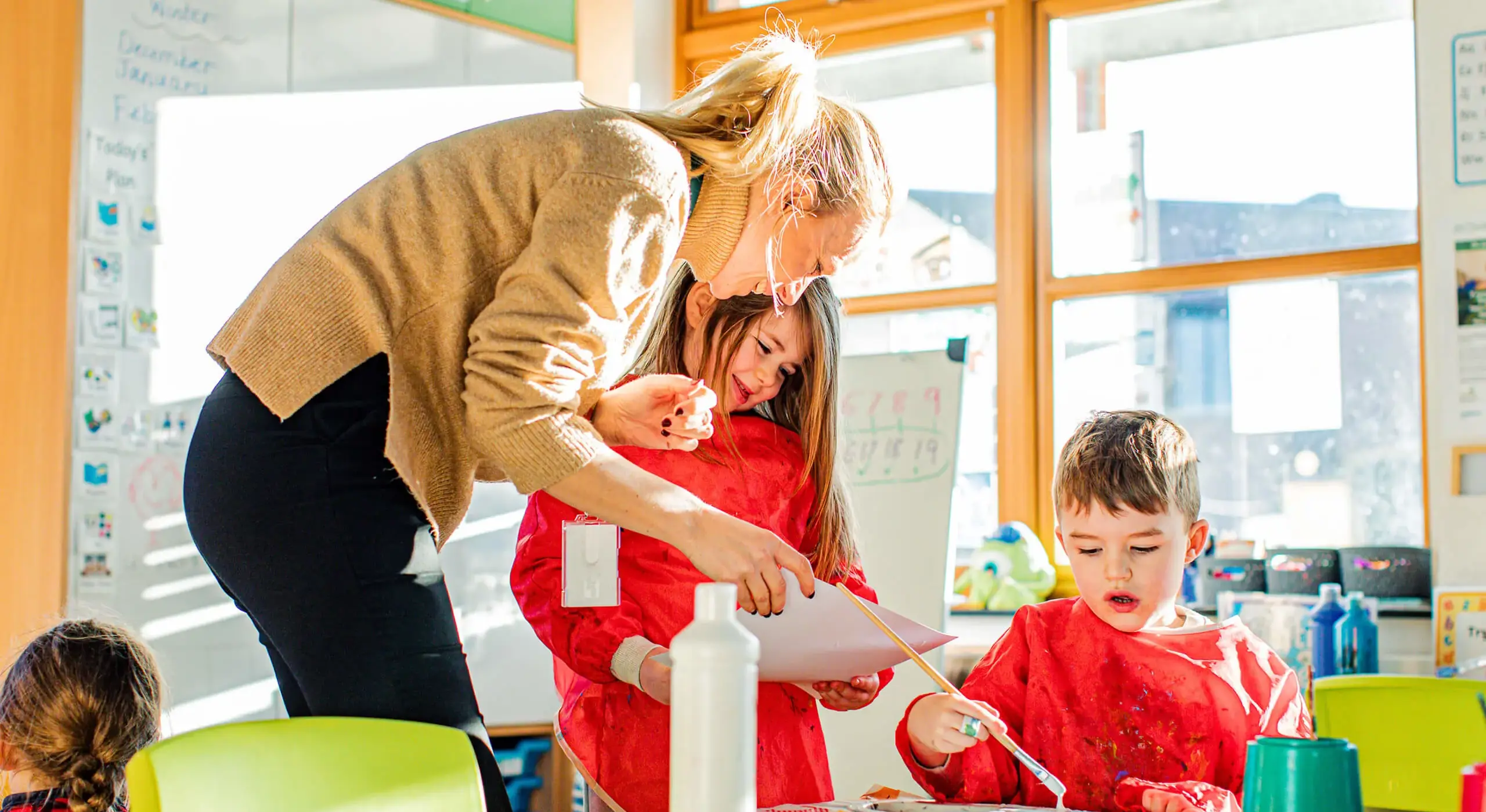 Junior school teacher in class with pupils at St Christopher's