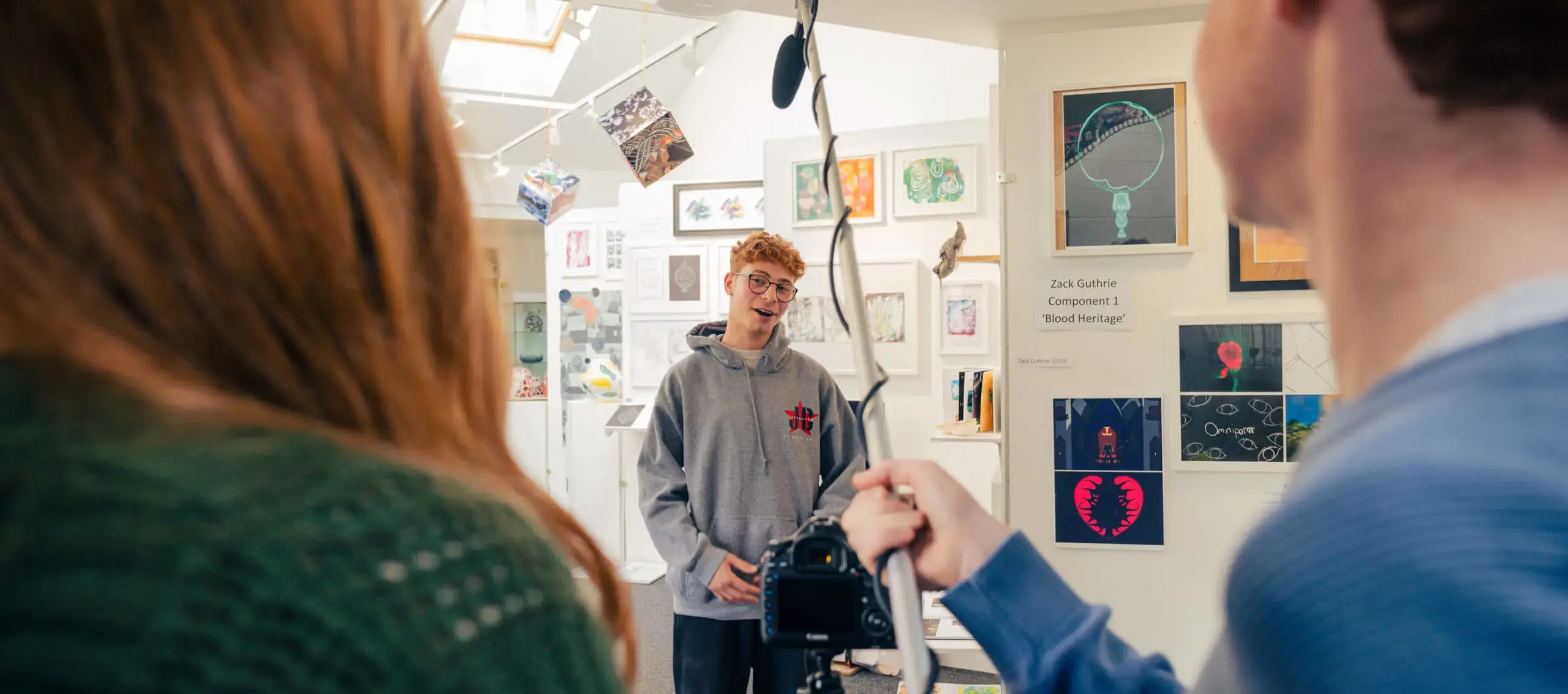 Students creating a film with a camera and boom microphone at St Chris in the art department